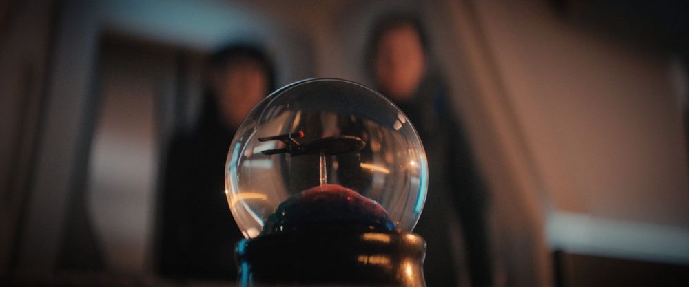 A close up of a snow globe containing a model of the NX-01 Enterprise, in the Star Trek: Discovery episode “All is Possible”.