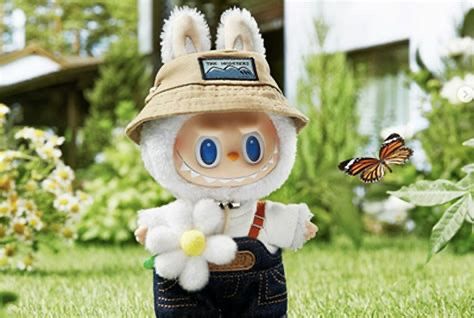 ein labubu im harten mit latzhose, fischerhut und blume in der hand