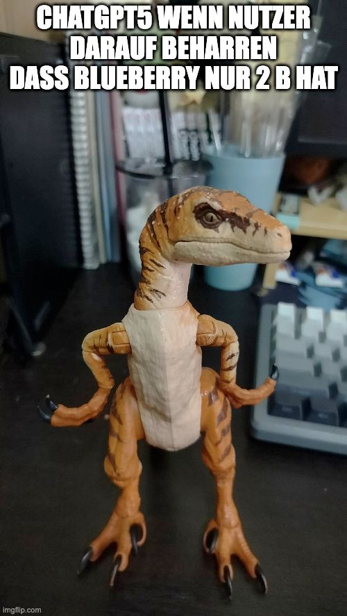 spiezeugfigur eines raptors mit den hämde an der hüfte angepisst zur seite guckend, dadrüber der text: "chatgpt5 wenn nutzer darauf beharren dass blueberry nur 2 b hat"