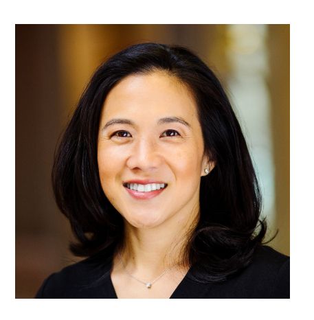 Angela has shoulder-length dark hair and is smiling at the camera