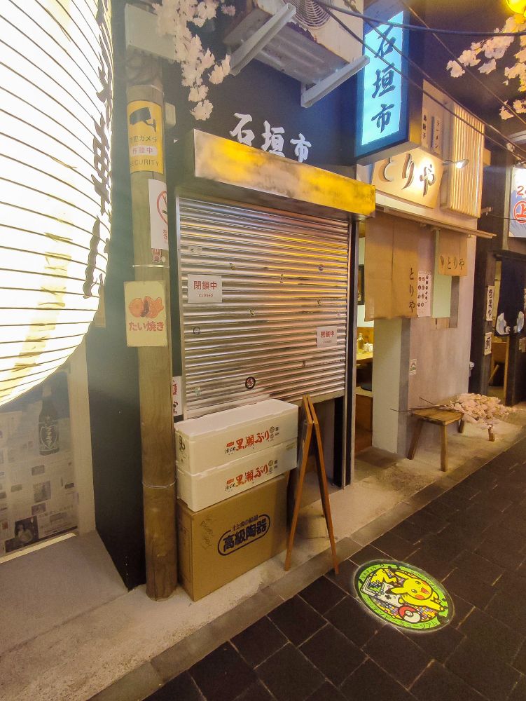 Recreation of a small japanese street with food signboards and neons, in a interior of the restaurant Ikimasho, Nantes.