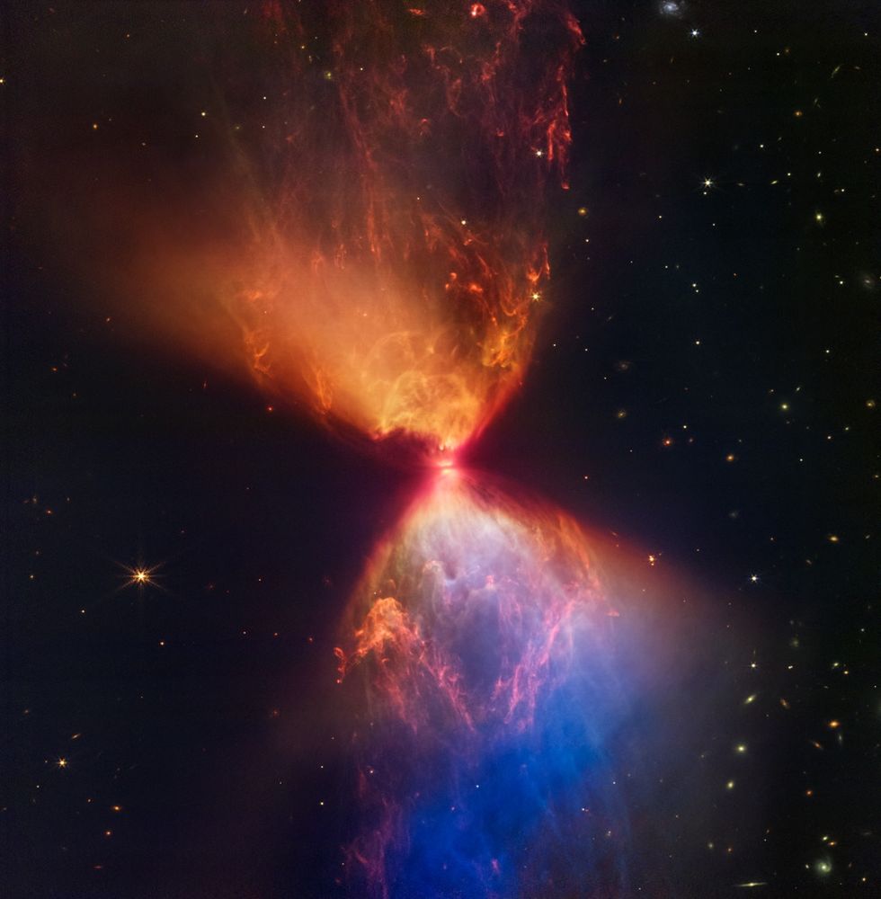 An image from the James Webb space telescope of the birth of a star. An hourglass shaped nova with a brilliant orange, red, and blue coloration.