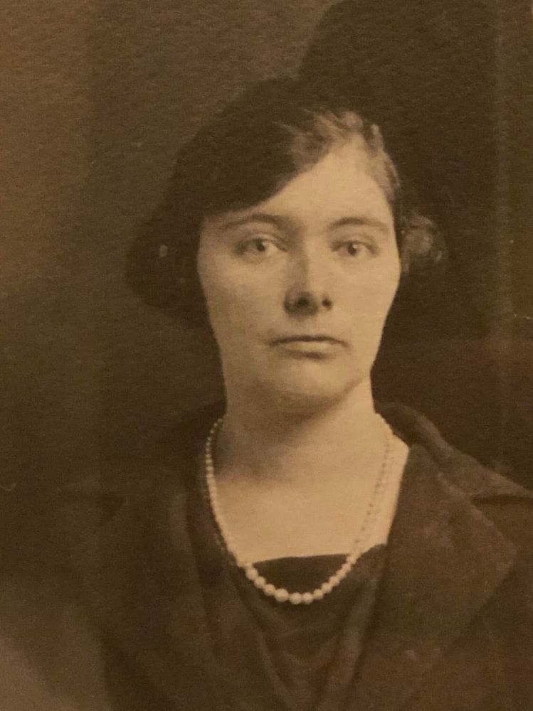 Photo of a woman wearing a necklace of pearls.
