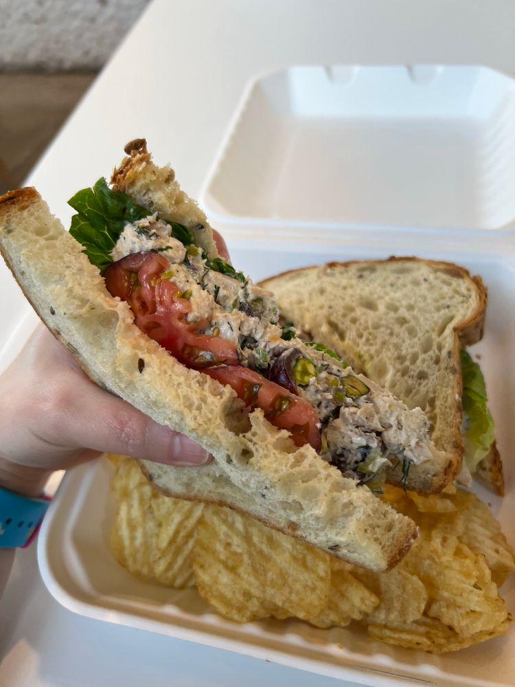 Cross section of pistachio chicken salad sandwich with chips