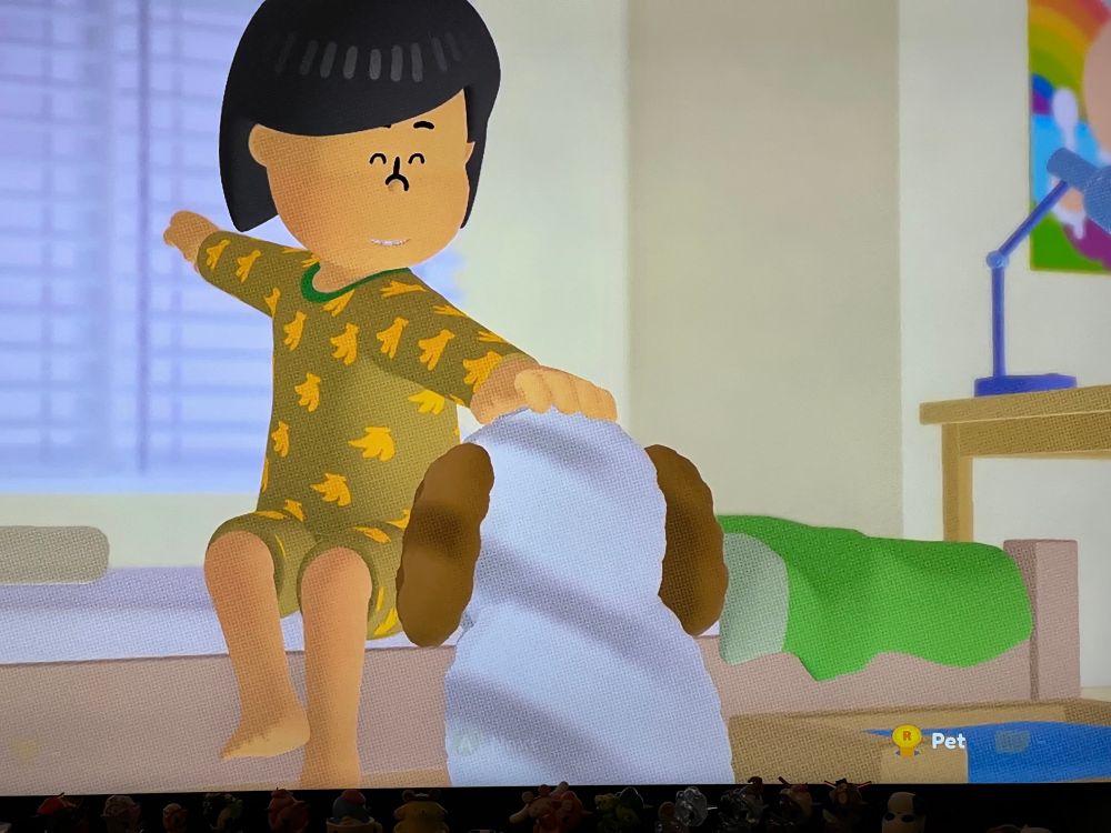 Photo of “to a T” on my TV with the main player character petting the dog