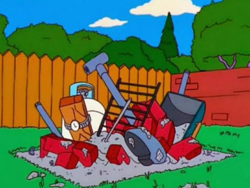 Screenshot from the Simpsons - Homer’s failed attempt to build a kit bbq. A tangled mess of concrete and various metal apparatus.