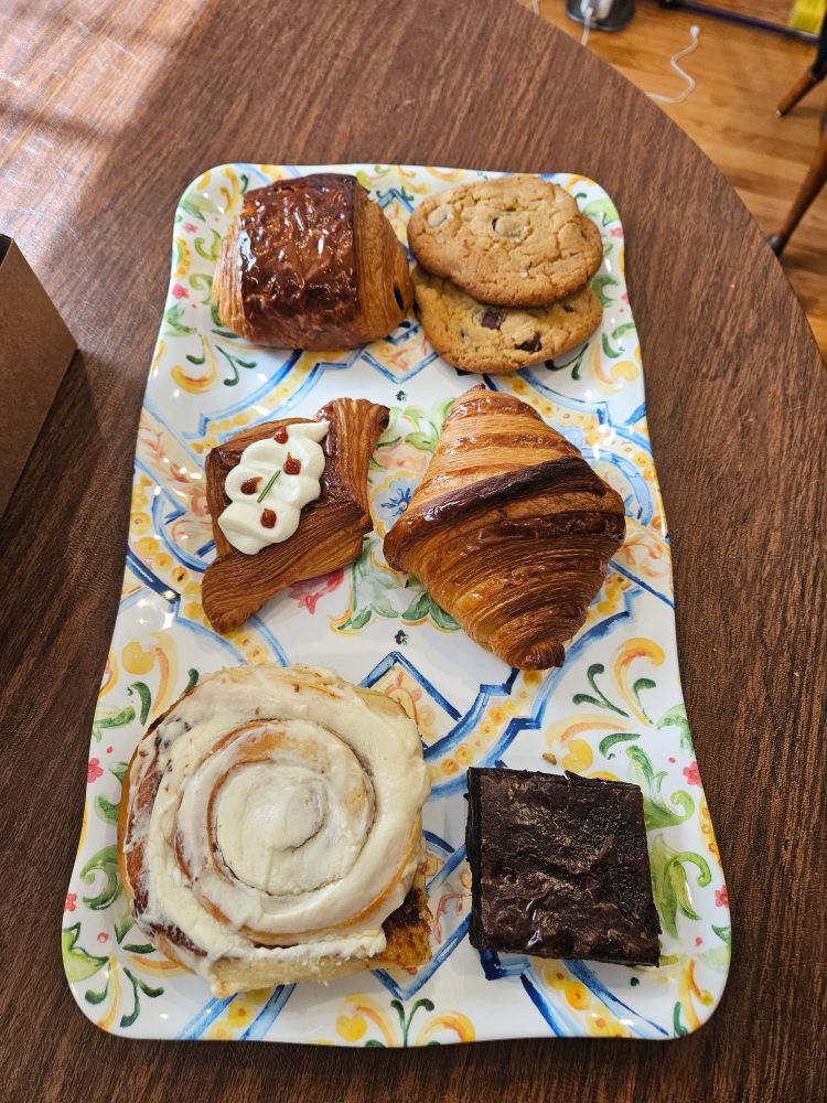Platter of pastries: pain au chocolate, brown butter chocolate chip cookies, crossaint, brownie, cinnamon roll and guava and cream cheese Danish. 