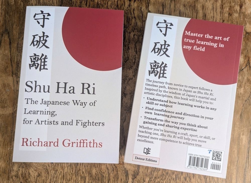 The front and back cover of 'Shu Ha Ri: The Japanese Way of Learning, for Artists and Fighters',  with a white and red design,. The back cover introduces the Japanese concept and its application to learning and teaching. It's authored by Richard Griffiths.