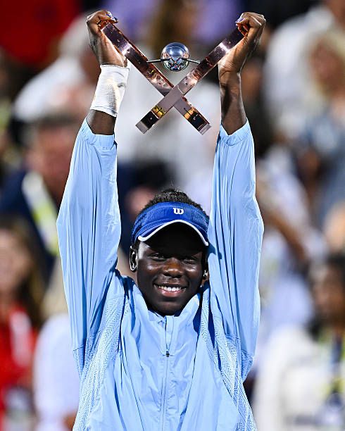 Victoria Moboko raises the WTA Montreal Champion’s trophy above her head, and smiles brightly ✨