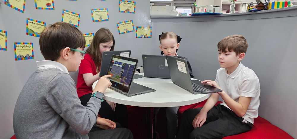 Four pupils use tablets.