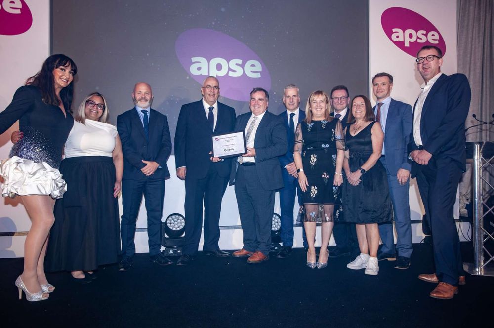 Politicians and senior managers from Renfrewshire Council stand together with presenters at the APSE Service Awards event. Council Leader Iain Nicolson holds the award for Council of the Year.