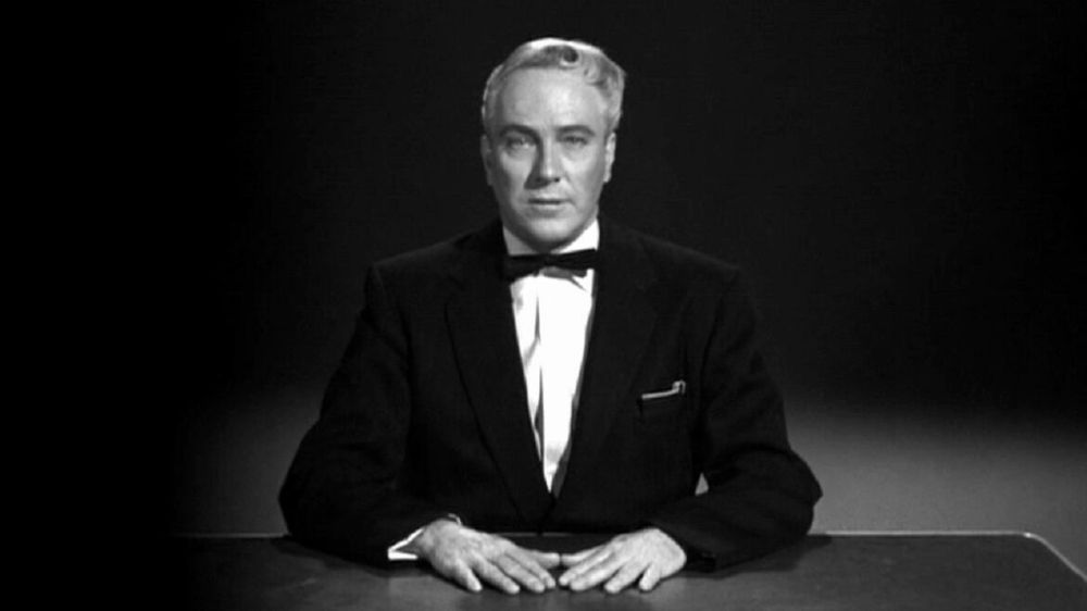 Phoney-baloney psychic Criswell seated behind a desk in the opening narration for Ed Wood's PLAN 9 FROM OUTER SPACE