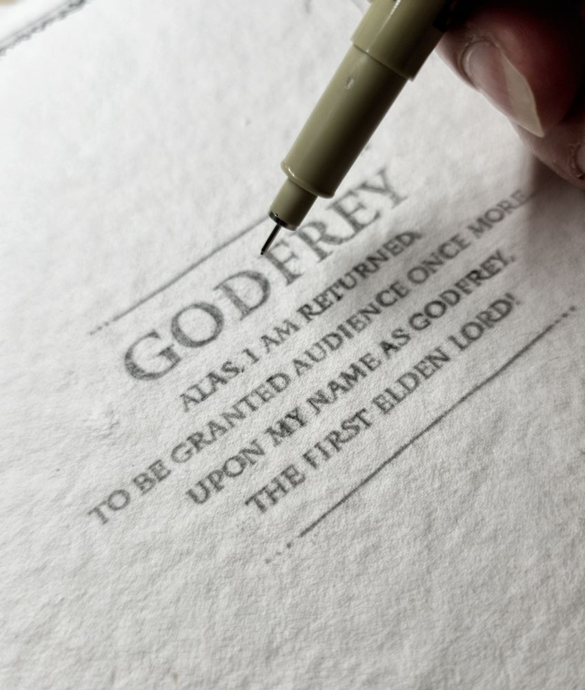 A piece of artisanal white paper with a text about Godfrey from Elden Ring video-game. It says! Alas I am returned. To be granted audience once more. Upon my name as Godfrey. The first Elden Lord. 