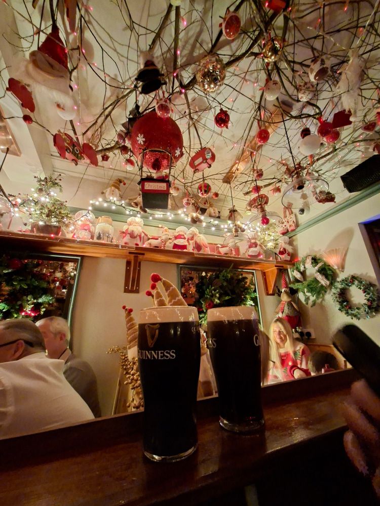 Two pints of Guinness against Christmas decorations 