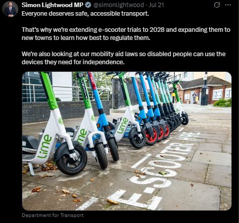 Screenshot of a tweet from Simon Lightwood MP. Jul 21. 
"Everyone deserves safe, accessible transport.
That’s why we’re extending e-scooter trials to 2028 and expanding them to new towns to learn how best to regulate them.
We’re also looking at our mobility aid laws so disabled people can use the devices they need for independence." Accompanied with a photo, the alt text for which was "Hire escooters parked in a line in a designated parking area", image attribution Department for Transport. 