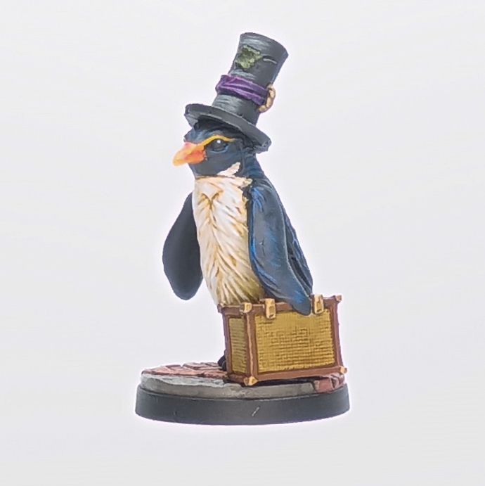 A fancy looking penguin stands on a red-brick lane in three quarter profile, holding a light brown carpet bag. His black feathers have a blue sheen, and his white breast looks fluffy from not having swam recently. His bright orange bill blends into his yellow eyebrows, underneath a worn but lovingly-patched top hat (so that you can tell he knows business). 
