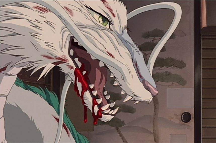 A close up frame of Haku as a dragon from the movie, Spirited Away. This shot is much more detailed. We can see fur on his snout, all of his sharp teeth, and his beautiful green eye with long lashes. He is snarling and covered in cuts, with blood streaked in his white fur. Blood drips from his mouth.