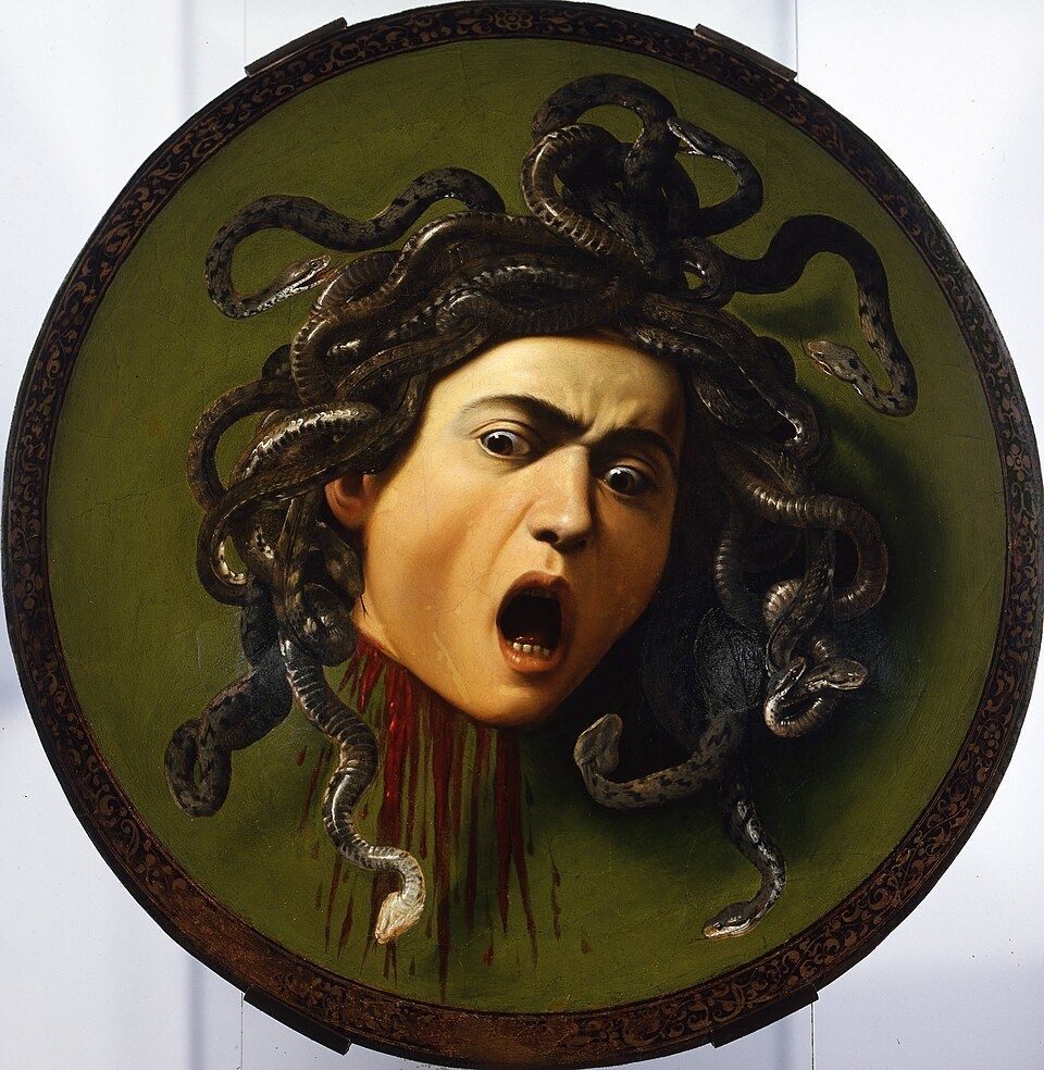 Dark painting on a convex wooden shield. It portrays the head of Gorgon Medusa after being beheaded by demigod Perseus, as the Greek mythology tells. She has dark snakes as her hair, a wide open mouth and a lot of blood coming out of her neck. The background is dark green.