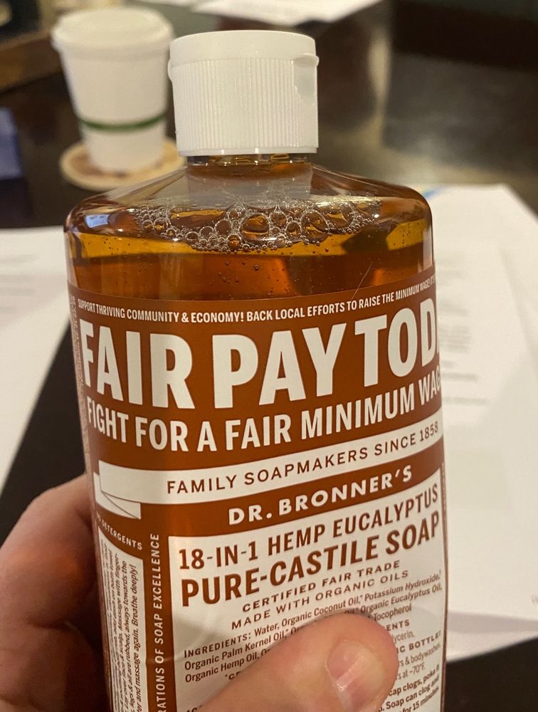 Bottle of Dr. Bronner’s liquid soap with special “Fair Pay Today” label