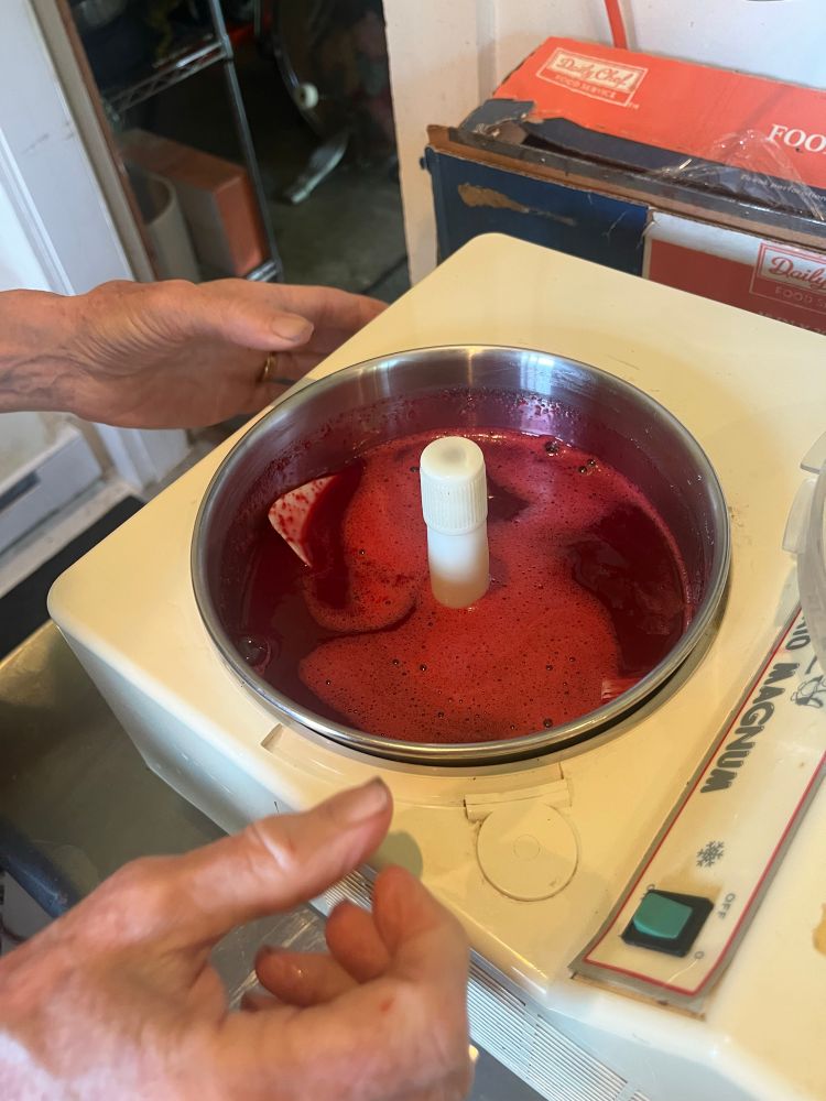 Bright red cherry mixture in an ice cream maker