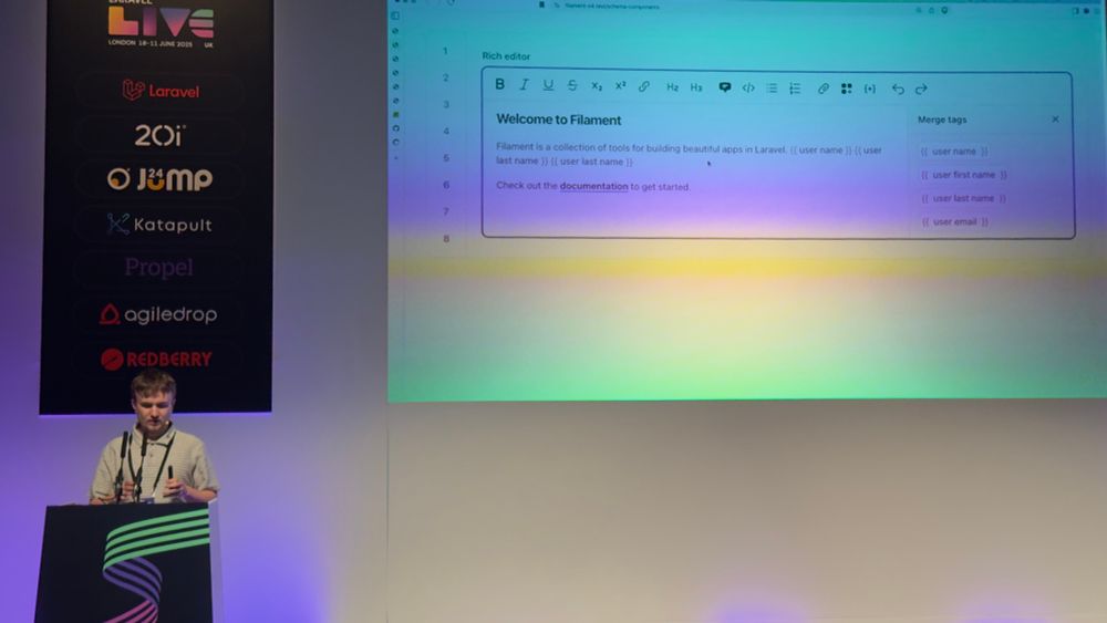 Photo of Dan introducing filament v4 at Laravel live uk. Show casing merger tags 