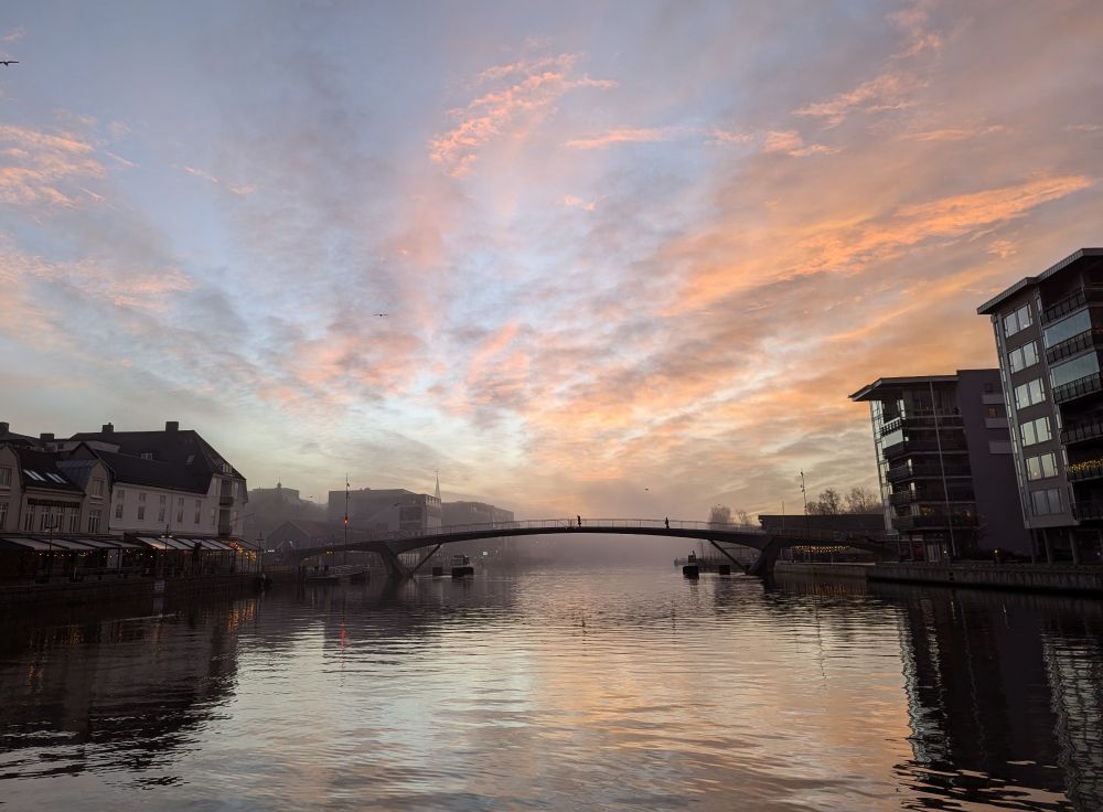 Partly cloudy, partly hazy morning view of Fredrikstad's city center, as seen from the middle of the Glomma river. 