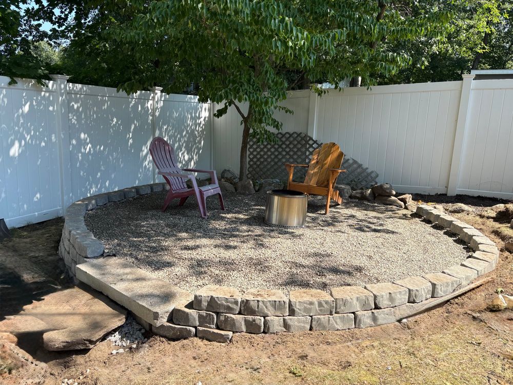 Large circular seating area with pea gravel on the finished surface, surrounded by retaining wall stones.