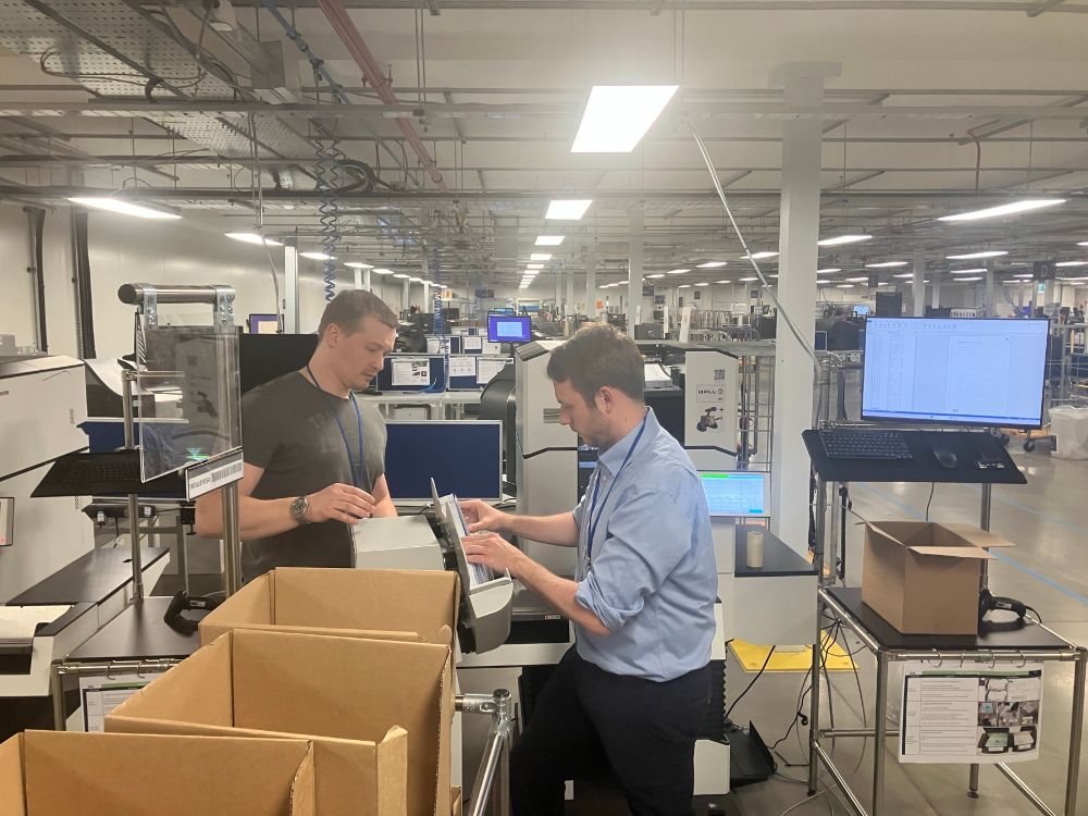 Two men at a machine inside.