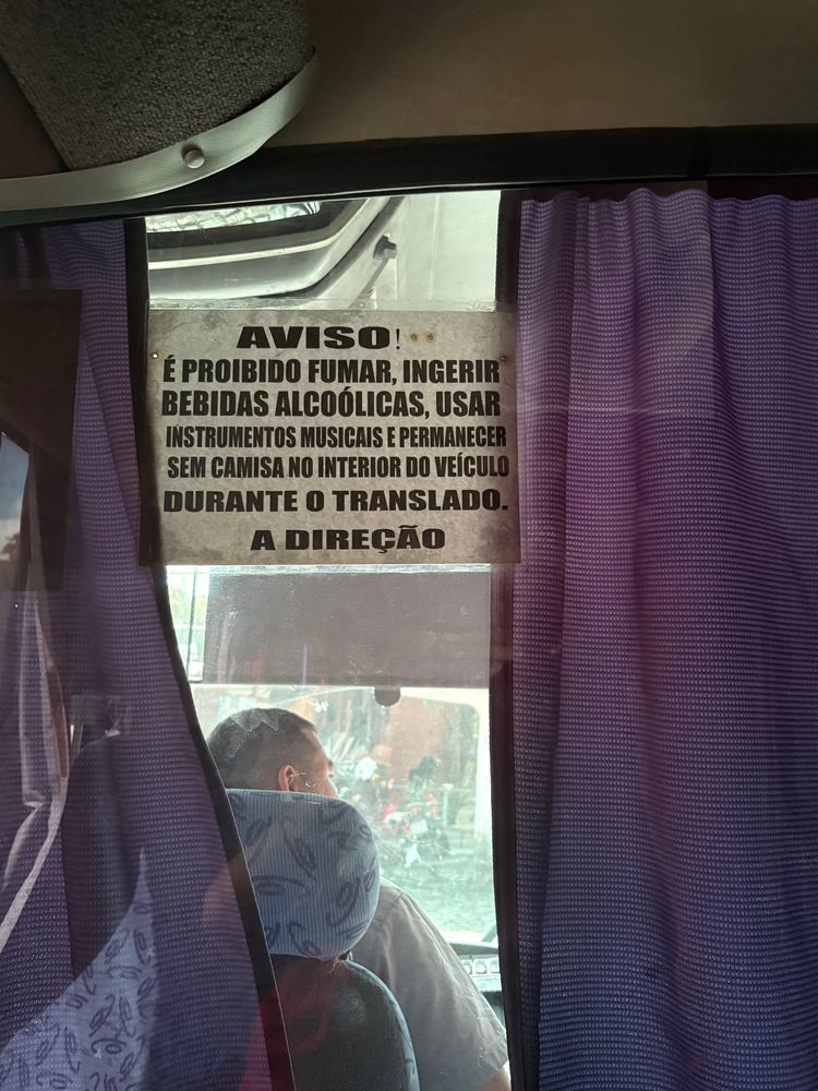 placa de aviso na janela de um onibus que diz:

AVISO!
É PROIBIDO FUMAR, INGERIR BEBIDAS ALCOÓLICAS, USAR INSTRUMENTOS MUSICAIS E PERMANECER SEM CAMISA NO INTERIOR DO VEÍCULO DURANTE O TRANSLADO.
A DIREÇÃO