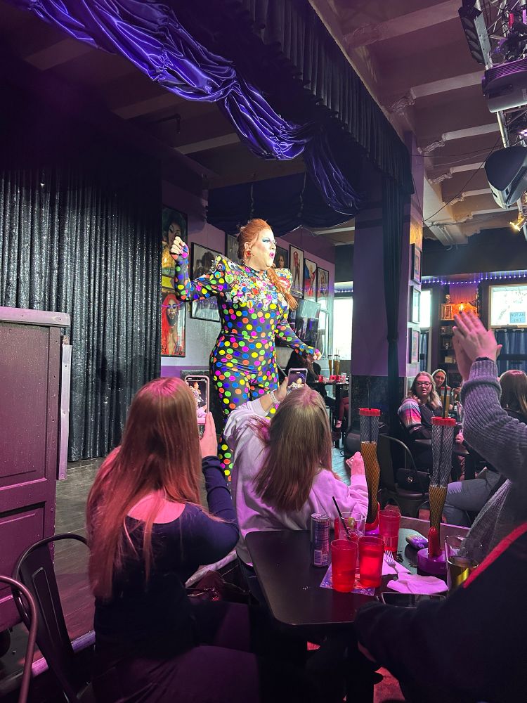 Colorful polka dot outfit with points shoulders and patches all along the top 