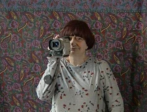 Agnes Varda holding a movie camera, making the connection between an old-fashioned gleaner and a modern documentary filmmaker.