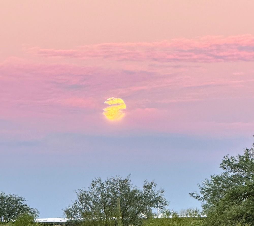Harvest moon in a purple and blue clouded sky.
