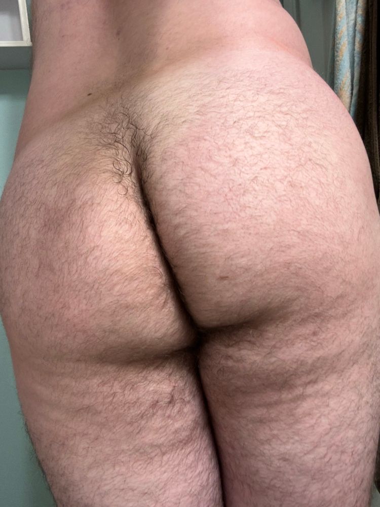 Man bent over and facing away from the camera, showing off his naked butt