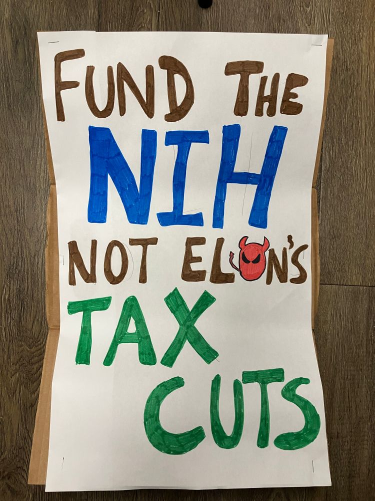 Poster saying: Fund the NIH, not Elon’s Tax Cuts.