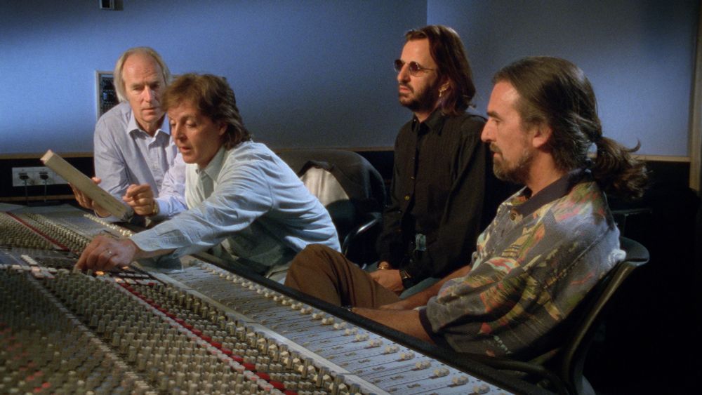 Photograph of the Threetles and George Martin at the mixing desk as seen in the Anthology. Harrison's shirt is simultaneously too bright and too dark.