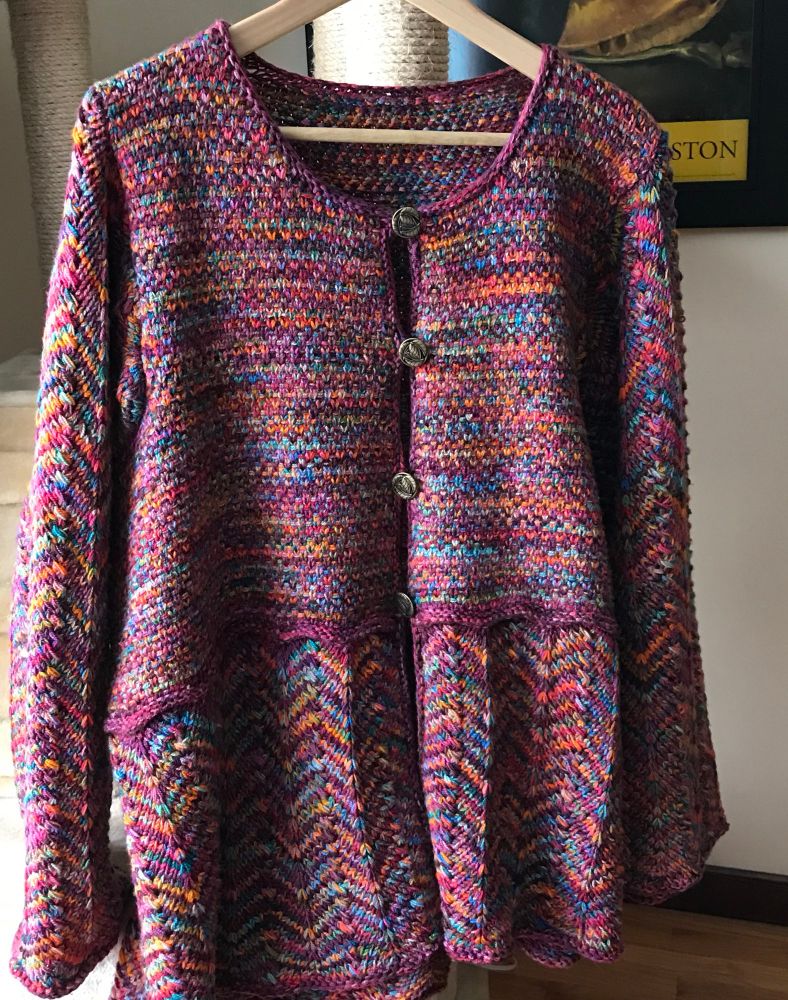A multicolored cardigan sweater with a chevron bottom and sleeves 