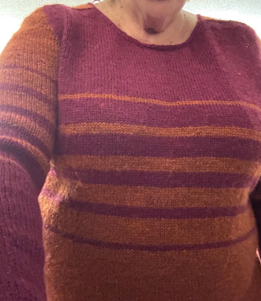 Magenta and orange striped sweater. The stripes are graduated in size
