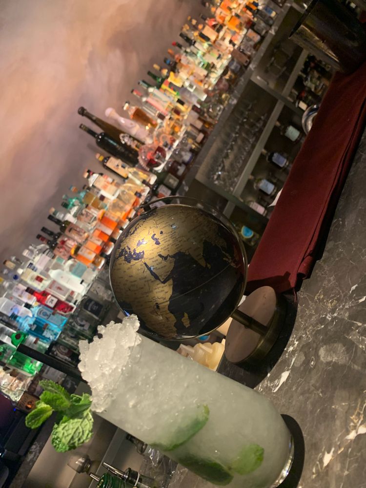 Image of a mojito and a world globe on the bar at ginger lily 