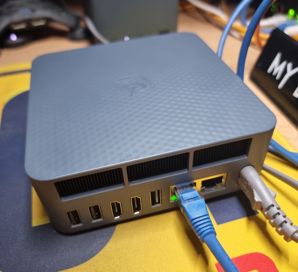 back of small grey box with 3 usb A, dual hdmi, dual 2.5gbit network ports and built in power supply