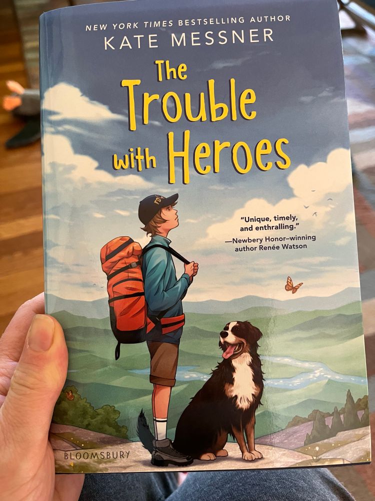 Cover of The Trouble with Heroes by Kate Messner that has an illustration of a boy with a backpack on a mountain with a dog.
