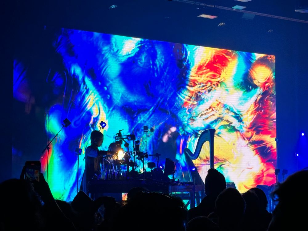 A woman live painting the visuals at a Floating points show at the Knockdown Center in Brooklyn, NY