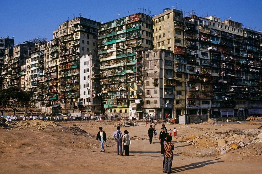 The Kowloon walled city, which used to be an extremely densely populated and largely lawless enclave of China. The image shows delapidated, structurally unsafe buildings with extreme crowding.