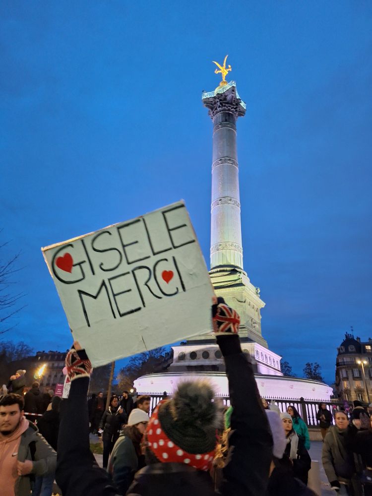 Manif NousToutes. Pancarte MERCI GISELE brandie face au Génie de la Bastille. 