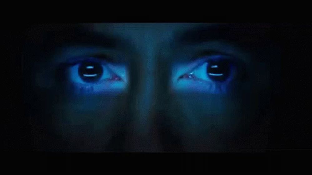 a close up of a person 's face with a blue light shining on it