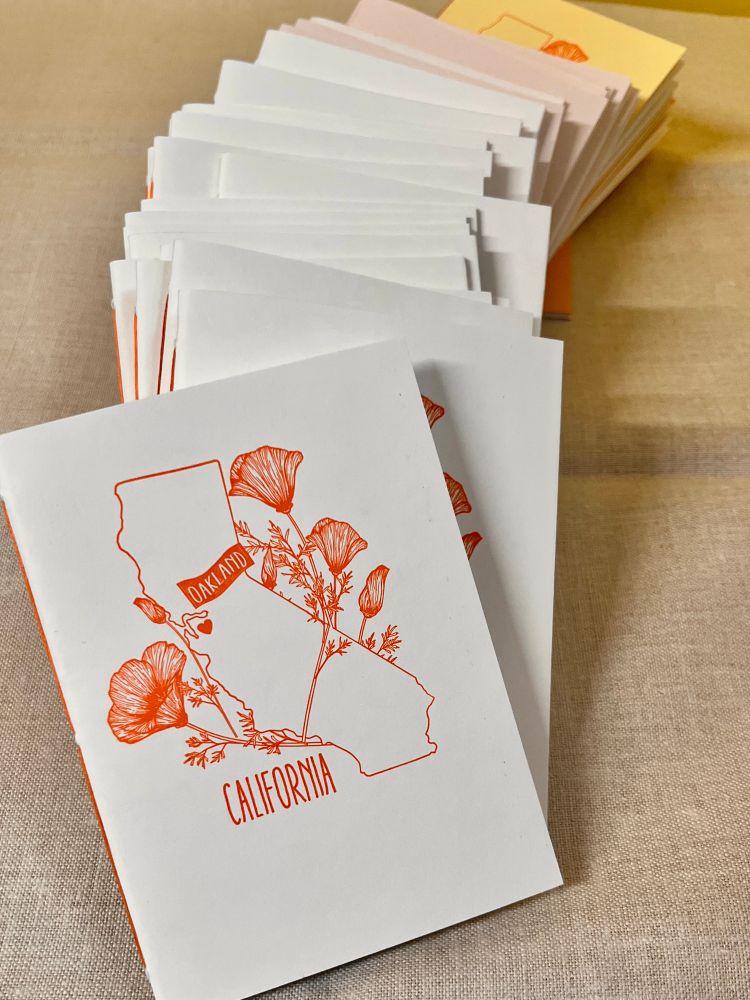 Small white booklets with orange print. 
