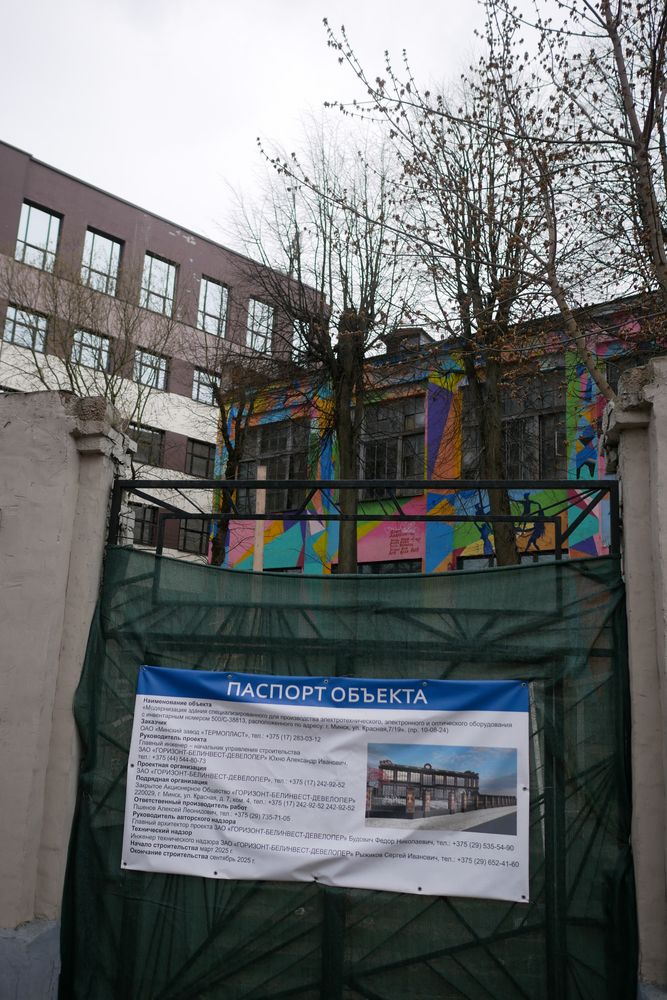 View of the central entrance to the former Cultural Center Korpus on Praspiekt Mašerava, 9. The entrance is closed, covered with a dark green mesh, with a construction plan pinned on it. The vibrant art space is now surrounded by dullness, banality and bad taste.