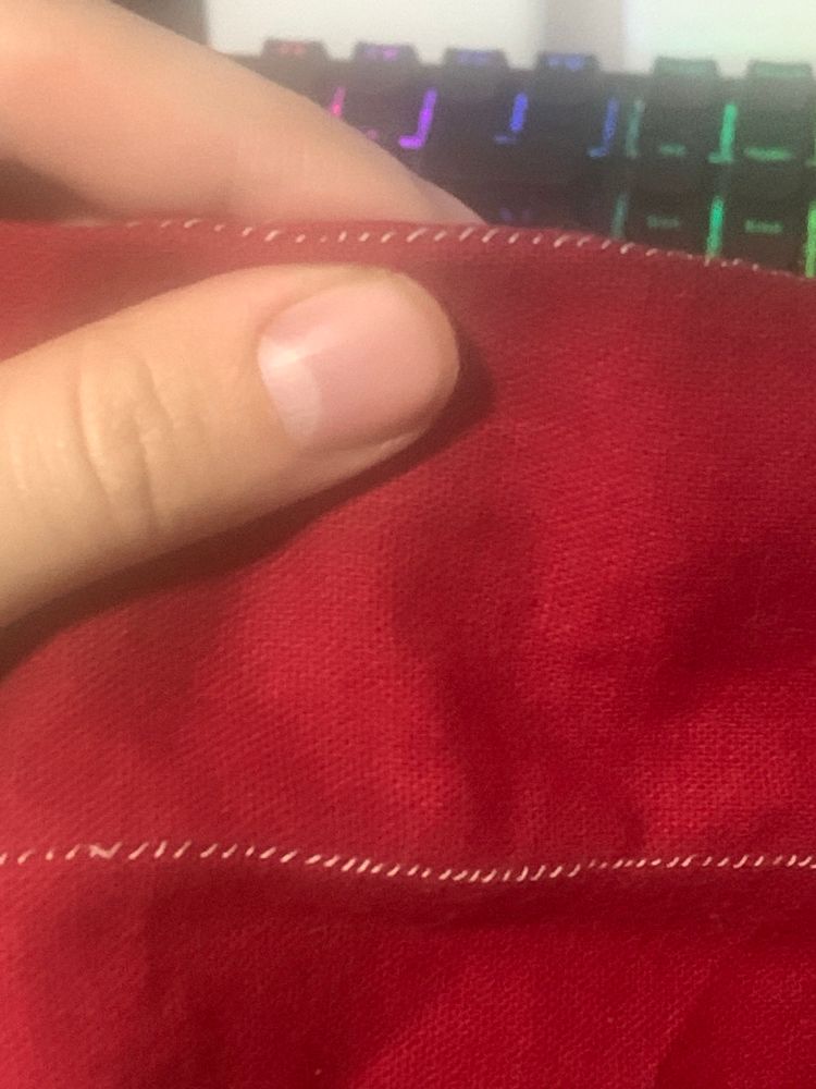 The Frankenstein gore is held up by index and thumb, pinching just below a seam so that the sewn thread sits on top of the fabric crease