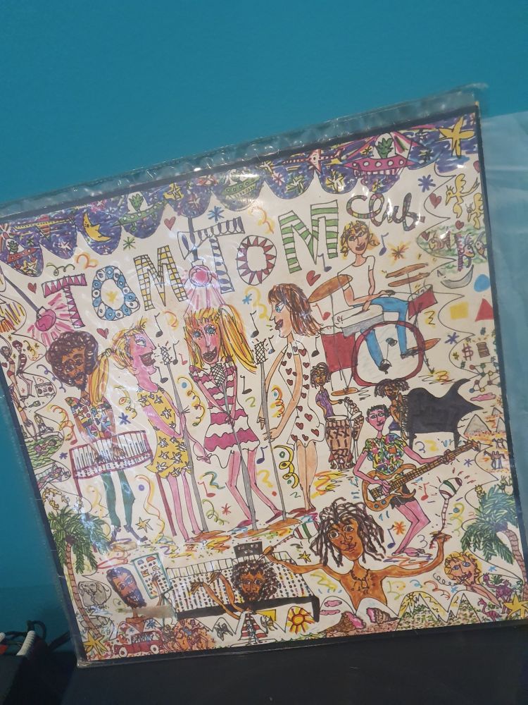 Cartoon drawing of a band with 3 female singers. It is childlike and whimsical. It is an album cover for Tom TOM Club