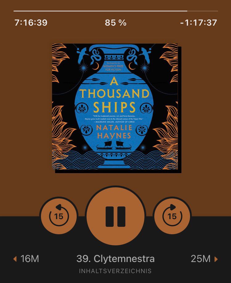 hörbuch "a thousand ships" von natalie haynes in einer hörbuch-app, das cover zeigt eine grafik in kräftigen farben: stilisierte bauchige vase mit schiffen, blumen und speeren, darum herum stilisierte flammen, unten wellen, oben stilisierter sternenhimmel. unter dem cover zeigt die app die kapitelüberschrift "clytemnestra" an.