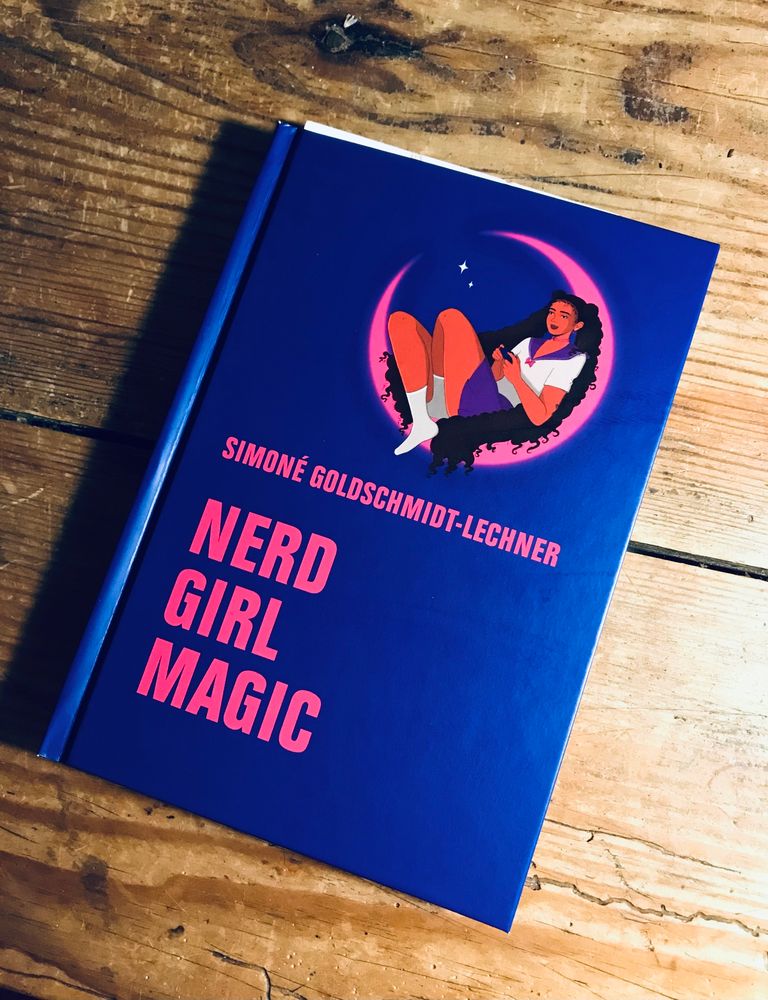 das buchcover von "nerd girl magic" von simoné goldschmidt-lechner, pinke schrift auf lila grundfarbe. coverillustration: eine BPoC sitzt mit mona-lisa-lächeln in einer pinken mondsichel, ihre hyperfeminine kleidung und ihre frisur mit zwei überlangen zöpfen ist stark an die (weißen) figuren der anime-serie sailor moon angelehnt. die person hält den controller einer spielkonsole in händen.
im halbkreis der mondsichel blitzen zwei sterne.
